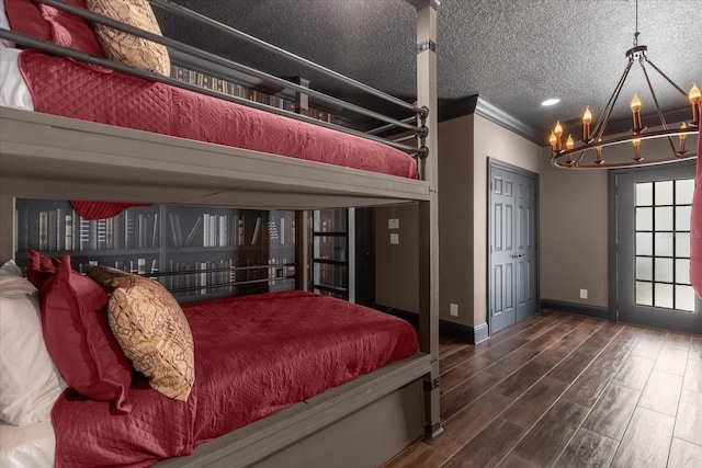 bedroom with hardwood / wood-style flooring, crown molding, a chandelier, and a textured ceiling