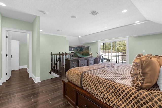 bedroom with access to outside, a textured ceiling, and dark wood-type flooring