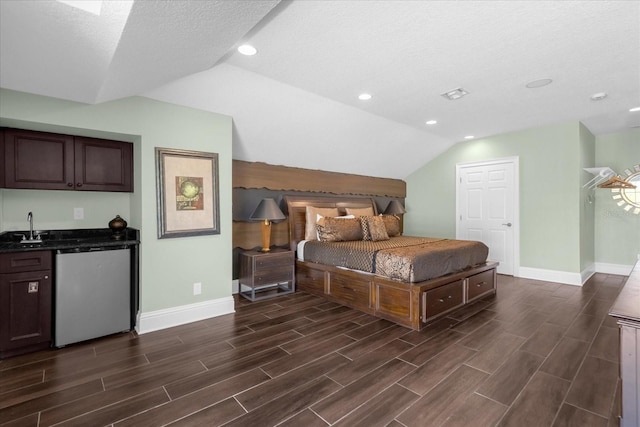 bedroom with indoor wet bar, lofted ceiling, a textured ceiling, and dark hardwood / wood-style flooring