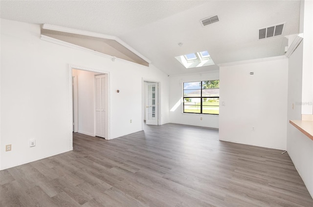 unfurnished living room with a textured ceiling, lofted ceiling with skylight, and hardwood / wood-style floors