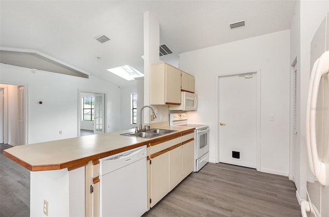 kitchen featuring sink, kitchen peninsula, light hardwood / wood-style flooring, white appliances, and lofted ceiling with skylight