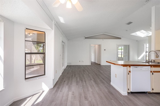 kitchen with light hardwood / wood-style floors, lofted ceiling with skylight, sink, and white dishwasher