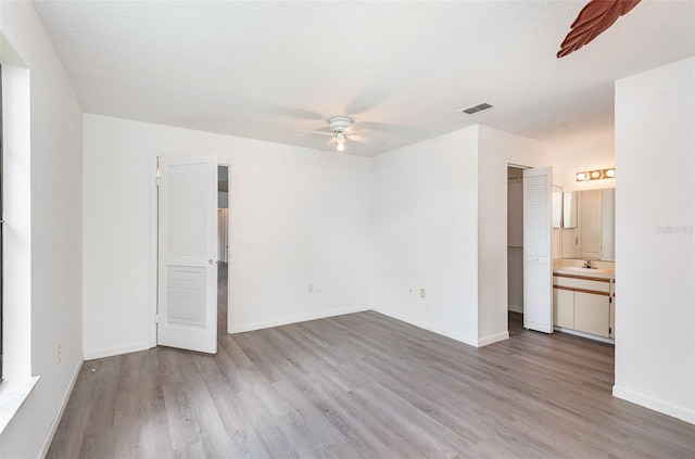 interior space with light wood-type flooring, a textured ceiling, and ceiling fan