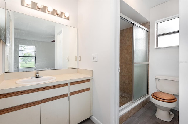 bathroom with walk in shower, vanity, and toilet