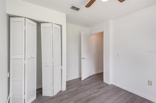 unfurnished bedroom with ceiling fan, light wood-type flooring, and a closet