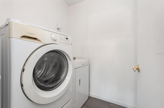 laundry area with dark hardwood / wood-style floors and washing machine and dryer