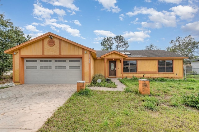 ranch-style house featuring a garage and a front lawn