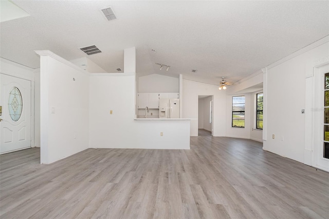 3186 Mapleshade St, Deltona, FL 32738 - unfurnished living room with lofted ceiling, light wood-style flooring, a textured ceiling, ceiling fan, and crown molding