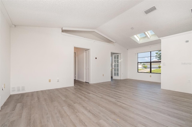 3186 Mapleshade St, Deltona, FL 32738 - spare room with a skylight, wood finished floors, vaulted ceiling, and a textured ceiling