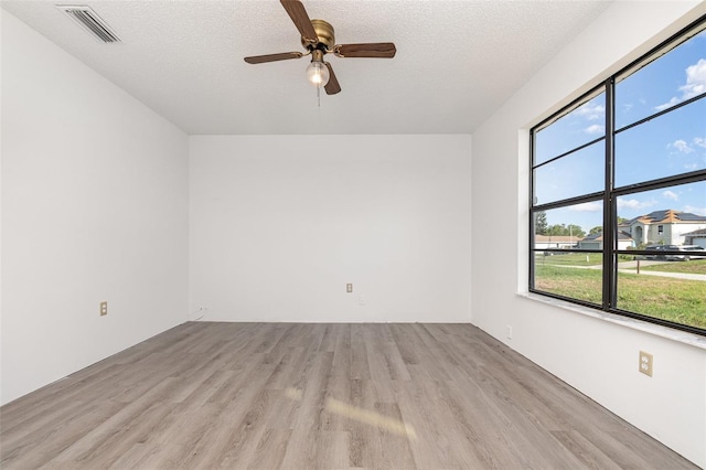 3186 Mapleshade St, Deltona, FL 32738 - spare room featuring light wood-style flooring, plenty of natural light, ceiling fan, and a textured ceiling