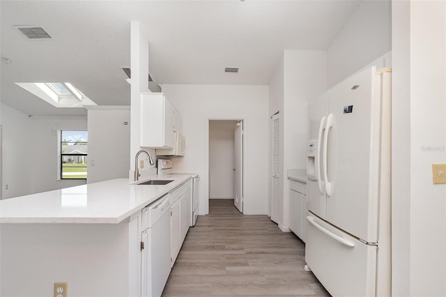 3186 Mapleshade St, Deltona, FL 32738 - kitchen with white appliances, a sink, a skylight, light countertops, and white cabinetry
