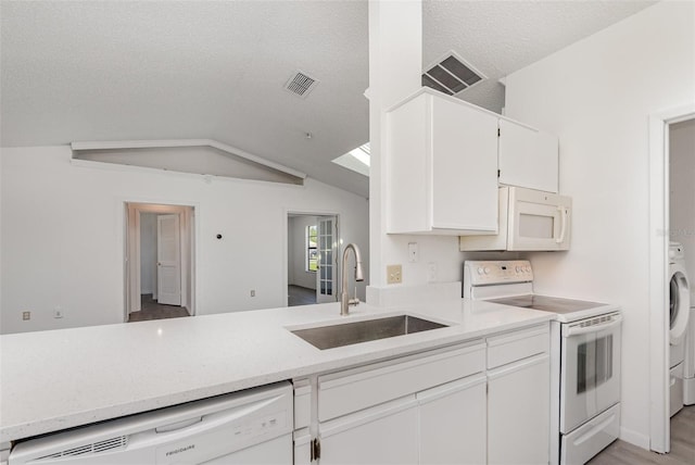 3186 Mapleshade St, Deltona, FL 32738 - kitchen with white appliances, a sink, a textured ceiling, white cabinets, and vaulted ceiling