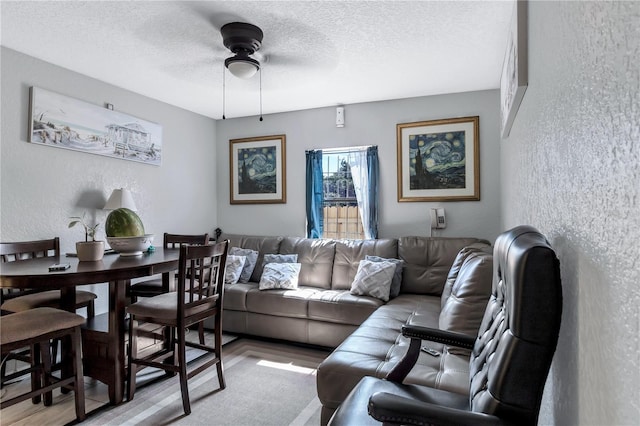 living room with ceiling fan and a textured ceiling