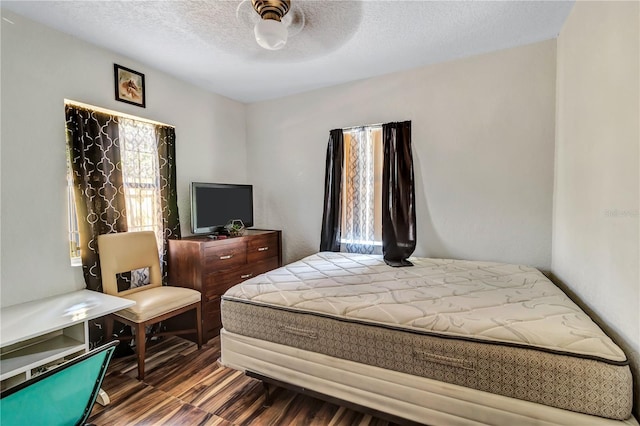 bedroom with ceiling fan, a textured ceiling, and hardwood / wood-style floors