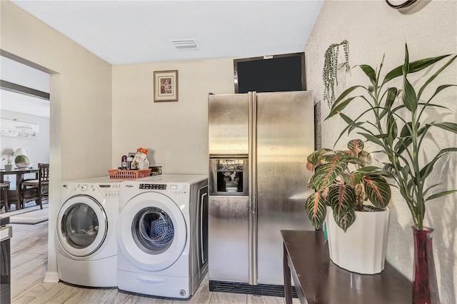 laundry room with separate washer and dryer and light hardwood / wood-style flooring