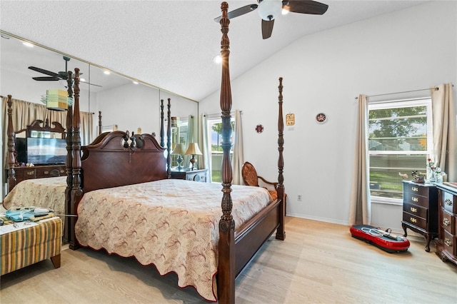 bedroom with light wood-type flooring, vaulted ceiling, a textured ceiling, and ceiling fan