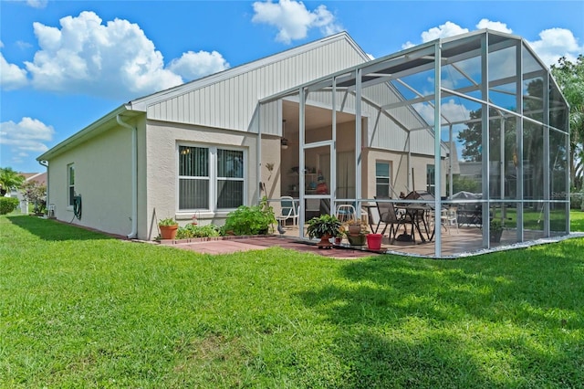 rear view of property featuring glass enclosure, a patio area, and a yard