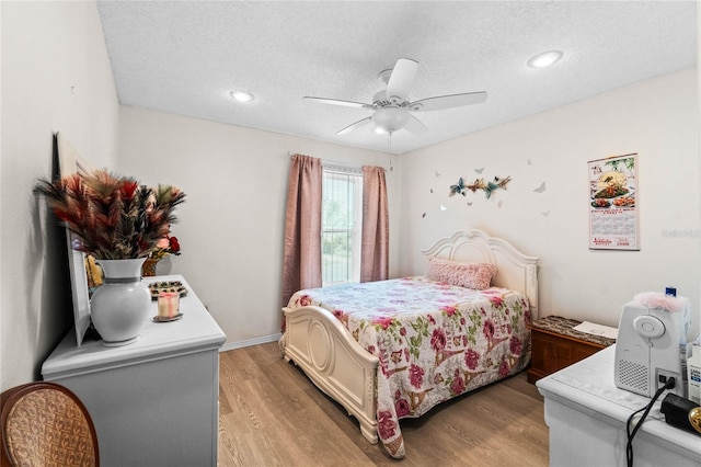 bedroom with ceiling fan, a textured ceiling, and hardwood / wood-style floors