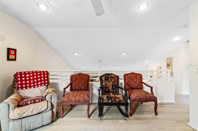 sitting room with vaulted ceiling and light hardwood / wood-style floors