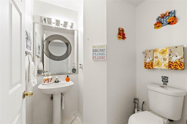 bathroom with toilet and tile patterned floors