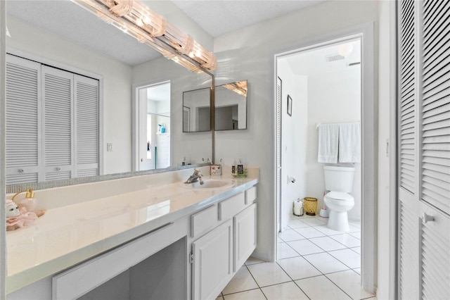 bathroom with vanity, tile patterned flooring, toilet, and a textured ceiling