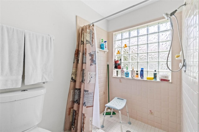 bathroom featuring a shower with curtain, tile patterned flooring, and toilet