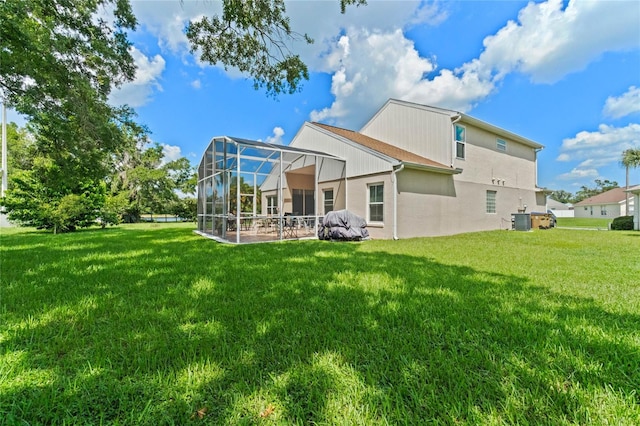 back of house with central AC, glass enclosure, and a lawn