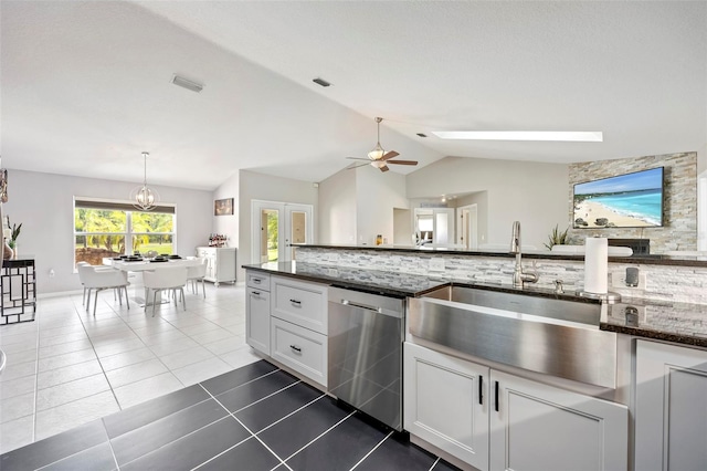 kitchen with white cabinetry, dishwasher, lofted ceiling with skylight, ceiling fan, and decorative light fixtures