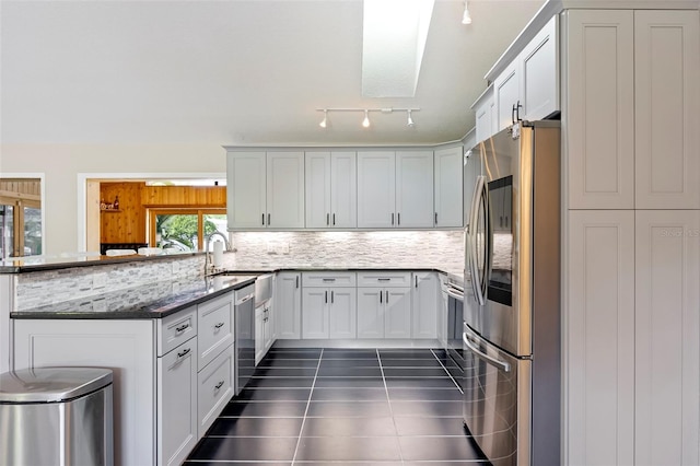 kitchen with white cabinets, a skylight, appliances with stainless steel finishes, and a healthy amount of sunlight