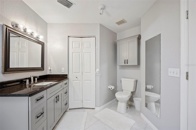 bathroom with tile patterned flooring, vanity, and toilet