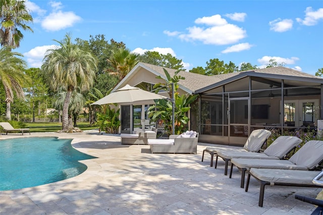 view of pool with a sunroom, a patio, and an outdoor hangout area