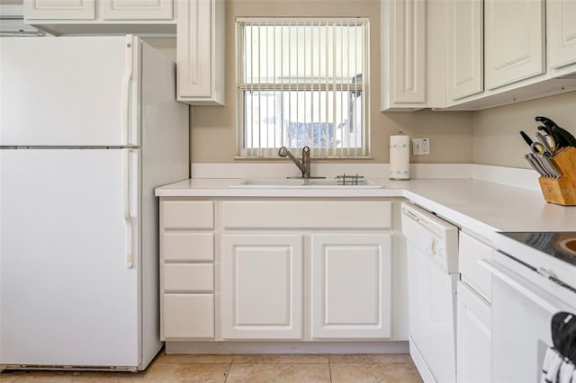 kitchen with white appliances, sink, light tile patterned floors, and white cabinets