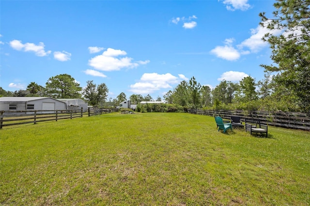 view of yard with a rural view and an outbuilding