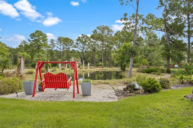 view of jungle gym with a lawn and a water view