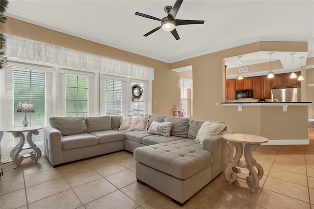 living room featuring ceiling fan, crown molding, and light tile patterned floors