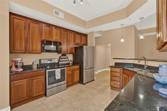 kitchen featuring dark stone countertops, pendant lighting, stainless steel appliances, crown molding, and sink