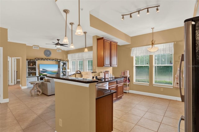 kitchen with kitchen peninsula, light tile patterned floors, pendant lighting, stainless steel appliances, and ceiling fan