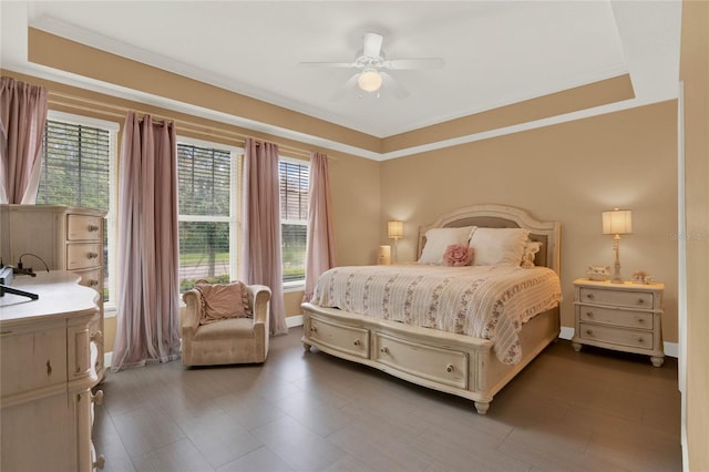 bedroom featuring multiple windows, a tray ceiling, ornamental molding, and ceiling fan