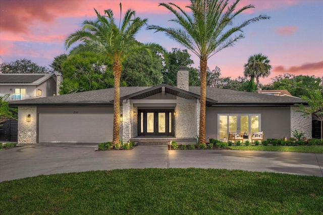 view of front of home with a garage and a yard