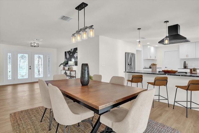 dining room featuring french doors and light hardwood / wood-style floors