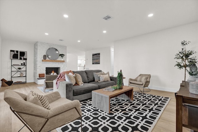 living room with a fireplace and light hardwood / wood-style flooring