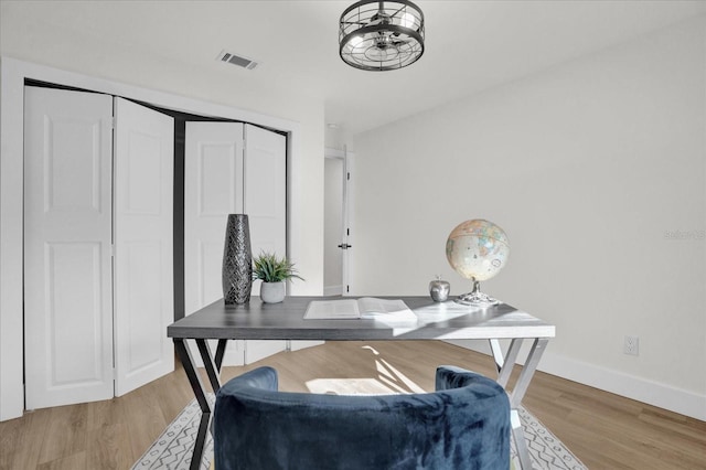 home office with light wood-type flooring and ceiling fan