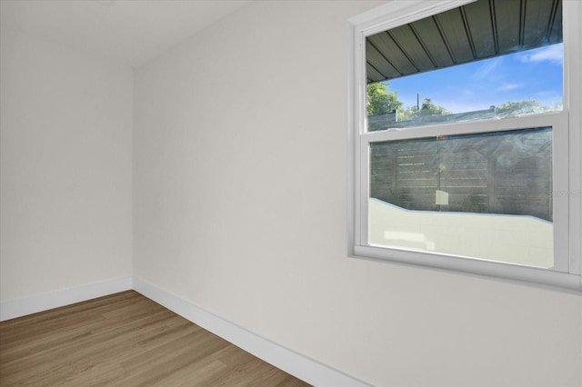 unfurnished room featuring a wealth of natural light and hardwood / wood-style floors