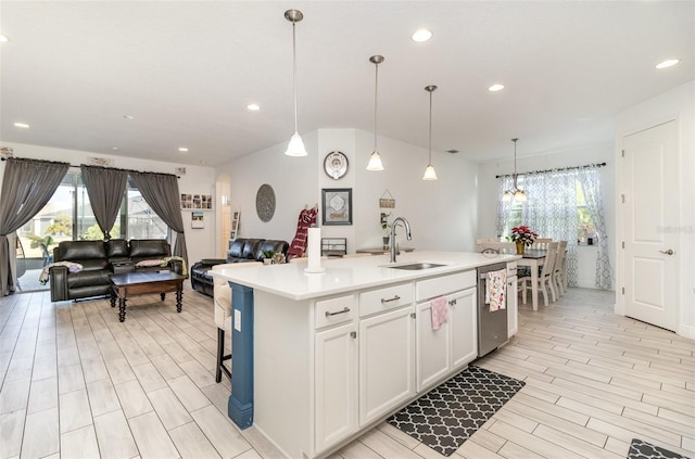 kitchen with dishwasher, sink, an island with sink, decorative light fixtures, and white cabinets