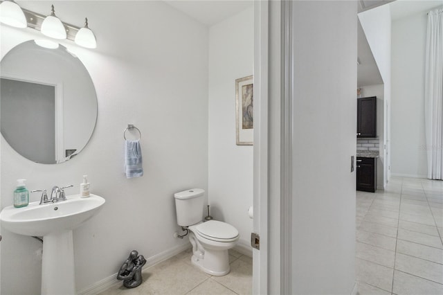 bathroom with tile patterned floors, toilet, sink, and decorative backsplash