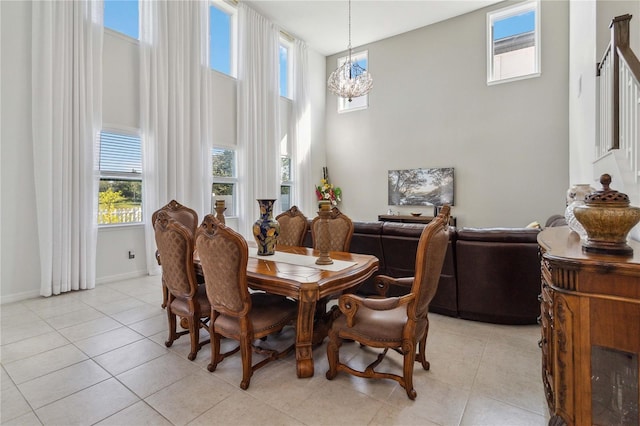 dining room featuring light tile patterned floors, a chandelier, and a high ceiling