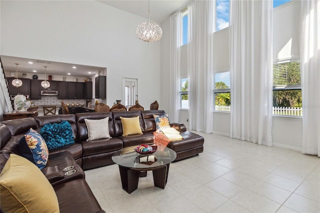 living room with light tile patterned flooring, a towering ceiling, and a chandelier