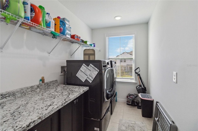 laundry area with independent washer and dryer and light tile patterned flooring