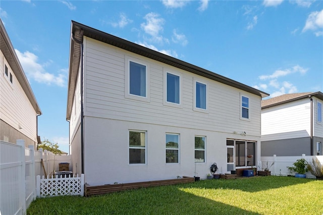 rear view of property with a lawn