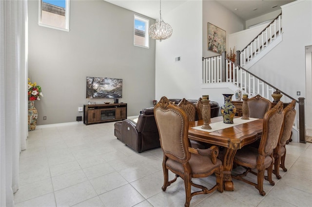 tiled dining space with a chandelier and a high ceiling